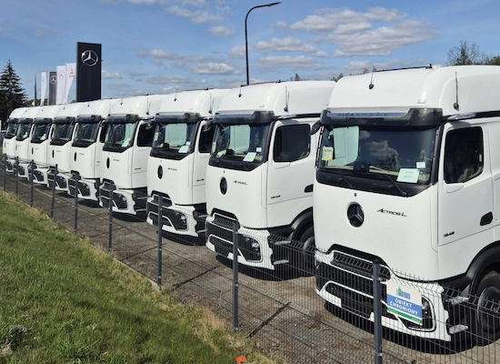 fleet of modern white freight trucks lined up at a European logistics company headquarters
